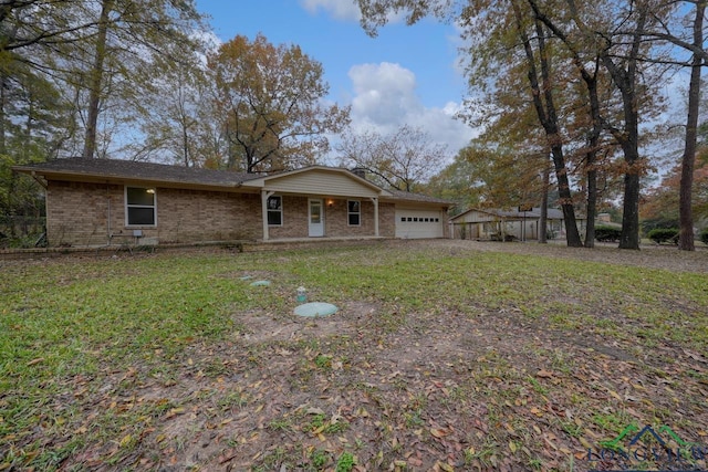 rear view of property featuring a garage and a yard