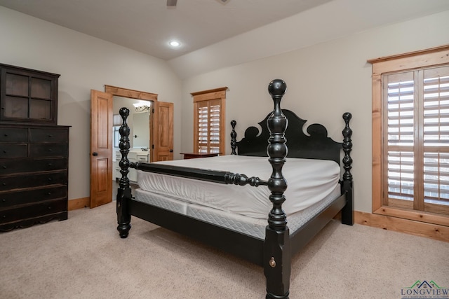 bedroom with light colored carpet and lofted ceiling