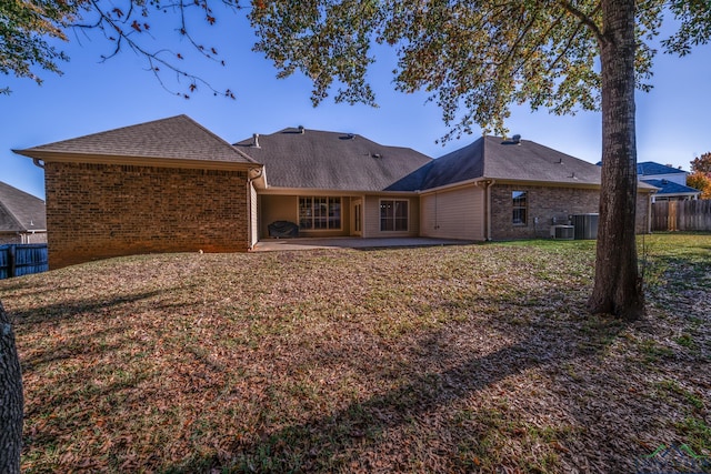 back of house with a lawn, central AC unit, and a patio area