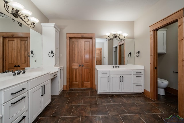 bathroom featuring vanity, a chandelier, and toilet