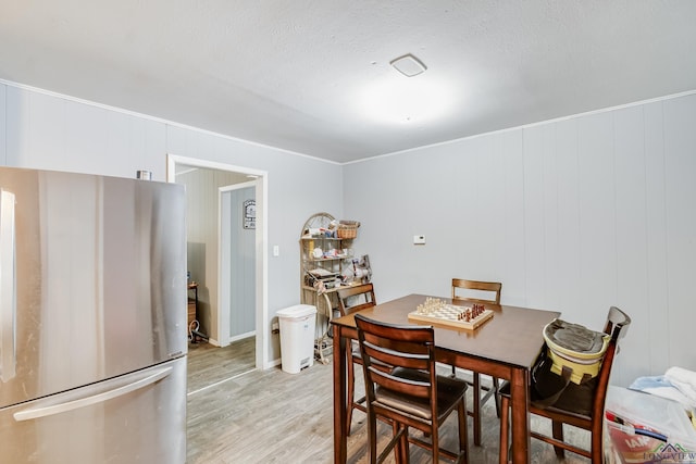 1504 Alice St, Gladewater, TX 75647 - dining area with light wood-type flooring, crown molding, and a textured ceiling