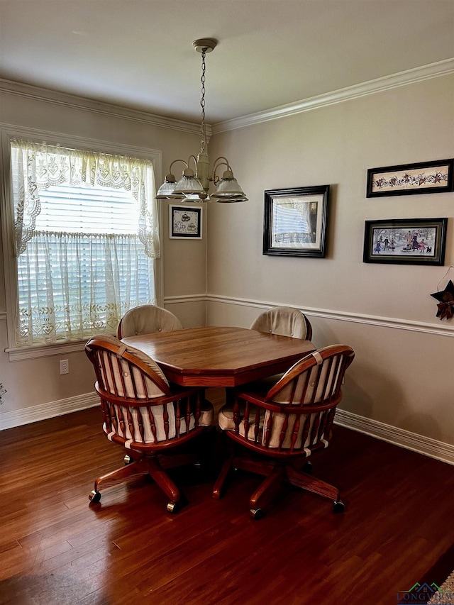 dining area with hardwood / wood-style flooring, crown molding, and an inviting chandelier