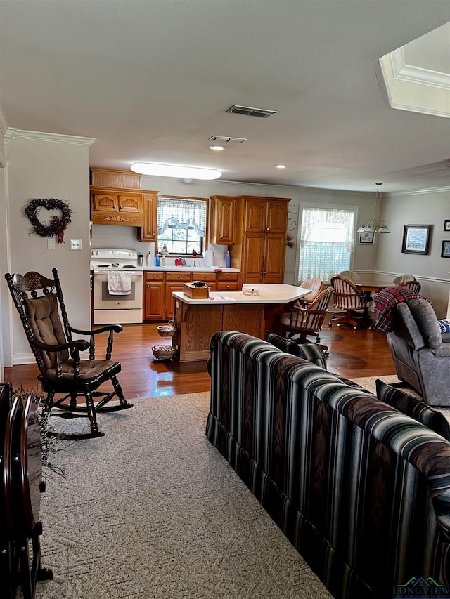 living room featuring a healthy amount of sunlight, light wood-type flooring, and ornamental molding