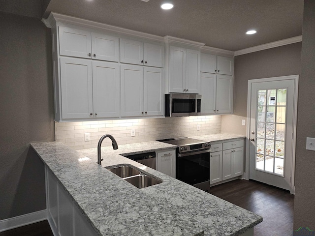 kitchen featuring sink, crown molding, appliances with stainless steel finishes, white cabinetry, and kitchen peninsula