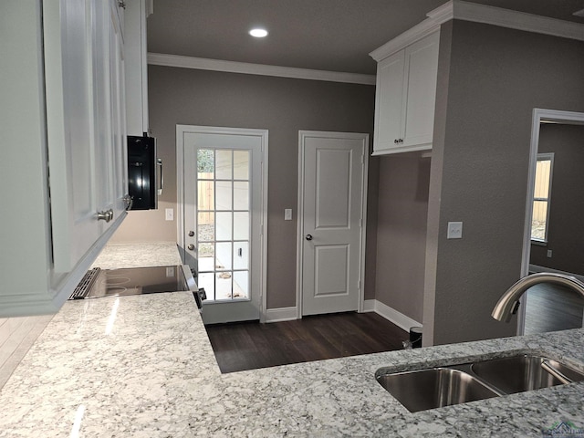 kitchen with white cabinetry, sink, ornamental molding, stove, and dark wood-type flooring