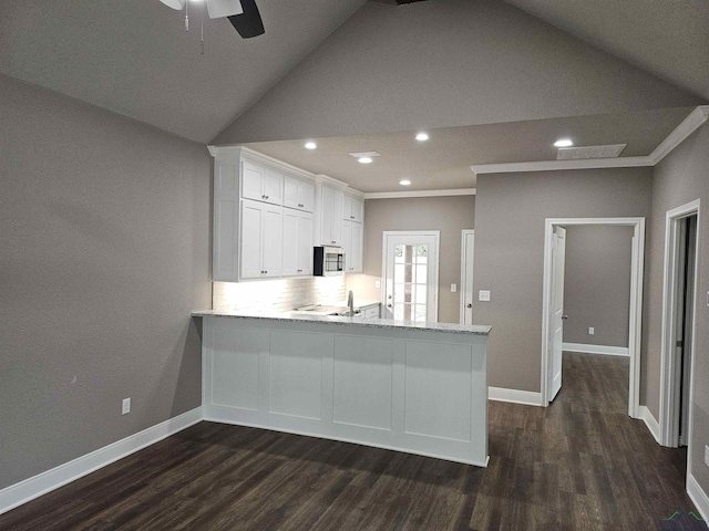 kitchen with ornamental molding, white cabinets, dark hardwood / wood-style flooring, and kitchen peninsula