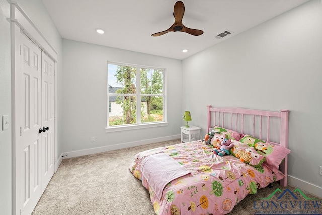 carpeted bedroom with ceiling fan and a closet