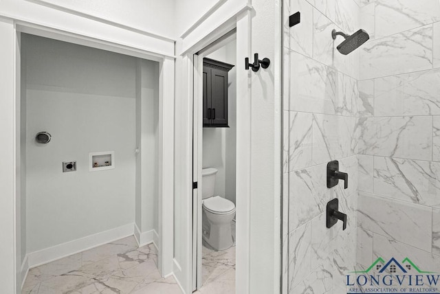 bathroom with a tile shower and toilet