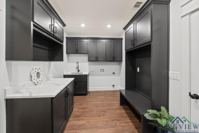 kitchen with light stone counters, sink, and dark hardwood / wood-style floors