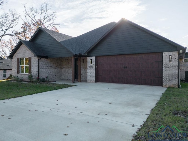 view of front of property with a front lawn, cooling unit, and a garage