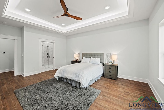 bedroom featuring hardwood / wood-style floors, a tray ceiling, and ceiling fan