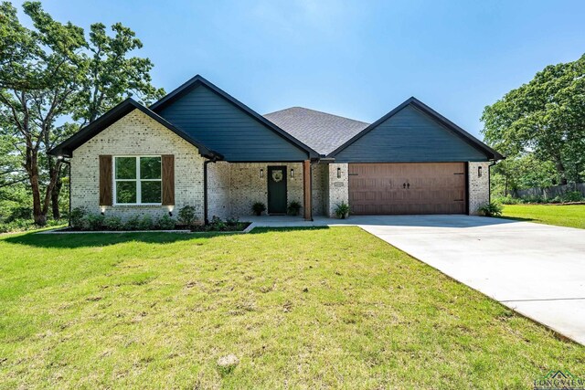 view of front of house featuring concrete driveway, a front lawn, an attached garage, and brick siding