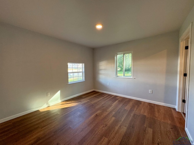 empty room with dark hardwood / wood-style flooring