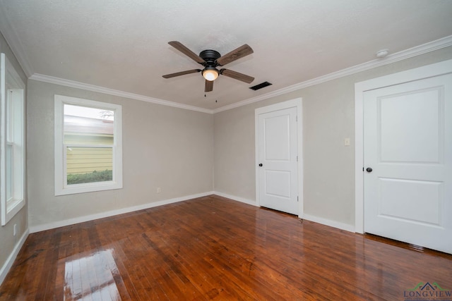 unfurnished room featuring ornamental molding, dark wood-type flooring, visible vents, and baseboards