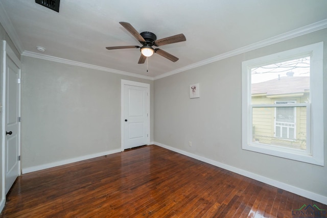 empty room featuring dark wood-style floors, crown molding, and baseboards