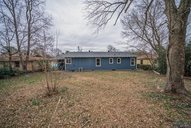 rear view of house featuring crawl space and a lawn