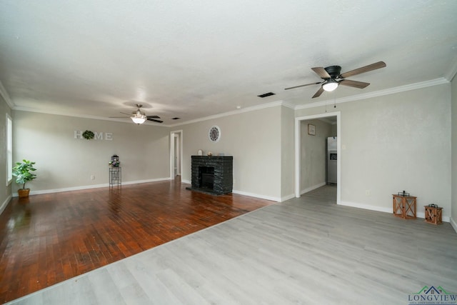 unfurnished living room featuring baseboards, visible vents, a fireplace with raised hearth, ornamental molding, and wood finished floors