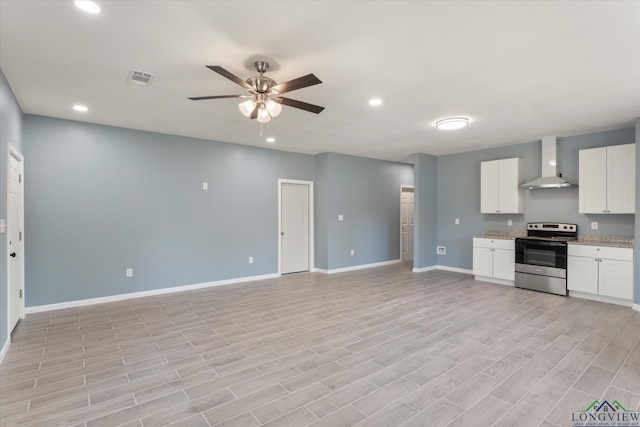 kitchen with white cabinetry, stainless steel range with electric cooktop, wall chimney exhaust hood, ceiling fan, and light hardwood / wood-style flooring