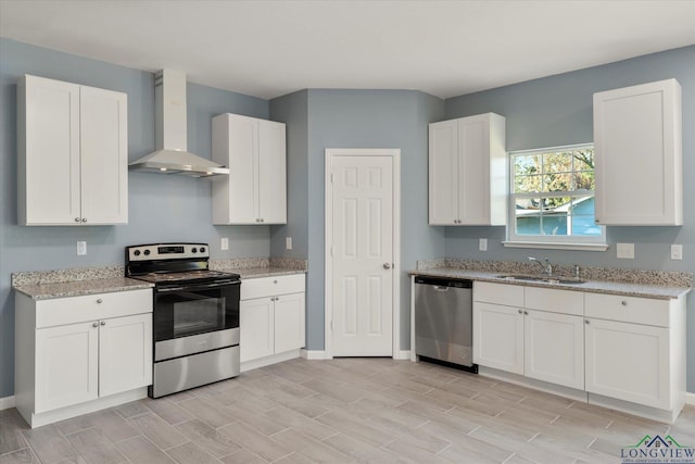 kitchen featuring white cabinetry, stainless steel appliances, sink, and wall chimney range hood