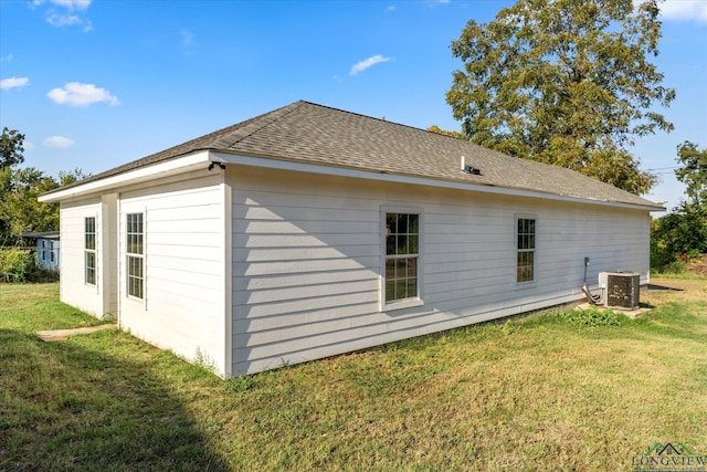 view of home's exterior with a yard and central AC