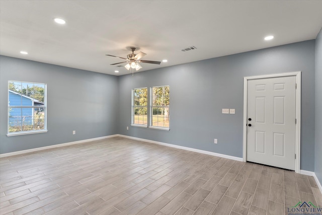 spare room featuring plenty of natural light, ceiling fan, and light wood-type flooring