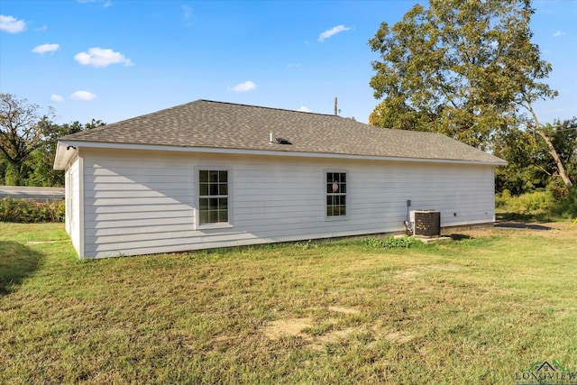 back of property featuring central AC unit and a yard