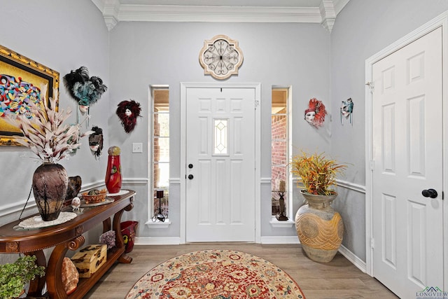 entrance foyer featuring ornamental molding and light wood-type flooring