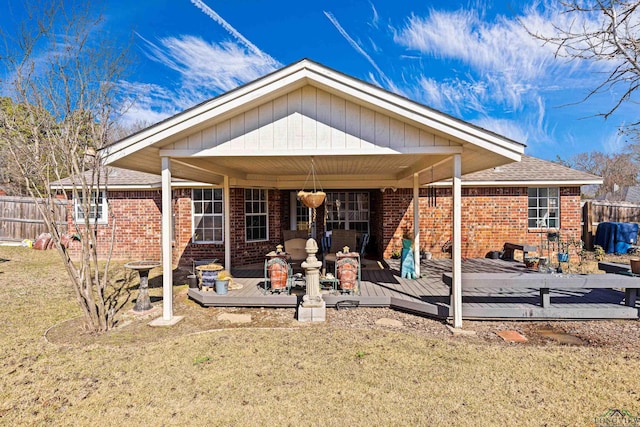 rear view of house featuring a deck and a lawn