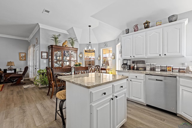 kitchen featuring dishwasher, a breakfast bar area, pendant lighting, and white cabinets