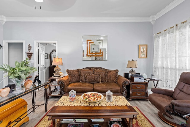 living room with ornamental molding, ceiling fan, and light hardwood / wood-style flooring