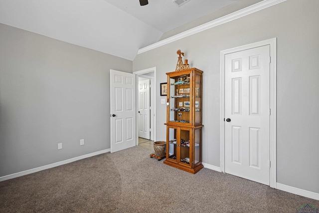 empty room with crown molding, ceiling fan, lofted ceiling, and carpet