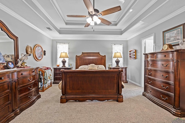 bedroom featuring light carpet, a tray ceiling, ornamental molding, and ceiling fan