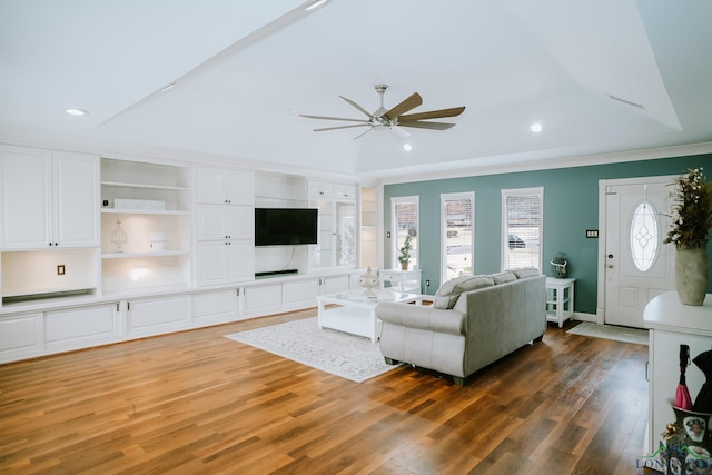 living room with dark wood-type flooring, ceiling fan, and crown molding