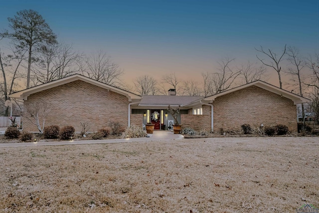 ranch-style home with a lawn