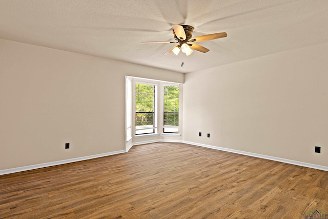 unfurnished room featuring a textured ceiling, wood finished floors, ceiling fan, and baseboards