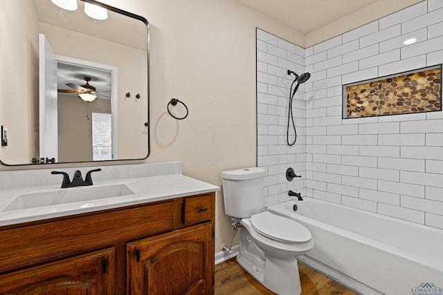 bathroom with vanity, a ceiling fan, toilet, tub / shower combination, and wood finished floors