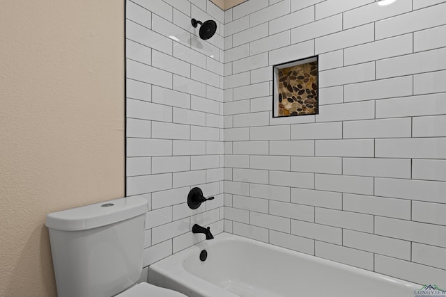 bathroom featuring a textured wall, toilet, and bathing tub / shower combination