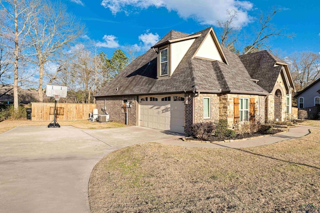 view of home's exterior featuring central AC, a garage, and a lawn