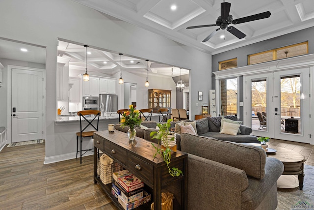 living room with beam ceiling, french doors, coffered ceiling, ceiling fan with notable chandelier, and dark hardwood / wood-style floors