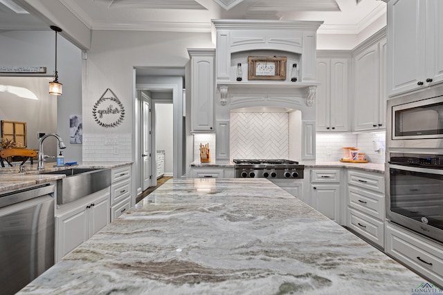 kitchen featuring appliances with stainless steel finishes, sink, white cabinetry, pendant lighting, and light stone countertops