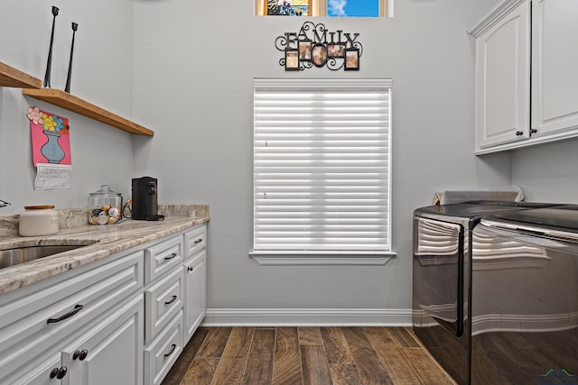 washroom with sink, a healthy amount of sunlight, dark hardwood / wood-style flooring, and washing machine and clothes dryer