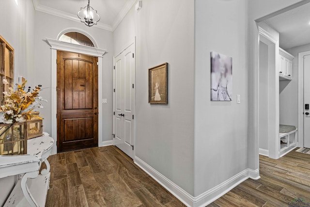 entrance foyer with ornamental molding, dark hardwood / wood-style floors, and a notable chandelier