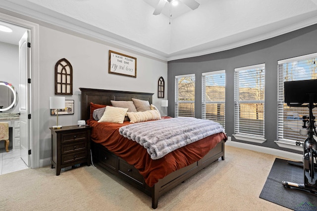 carpeted bedroom featuring lofted ceiling, crown molding, connected bathroom, and ceiling fan