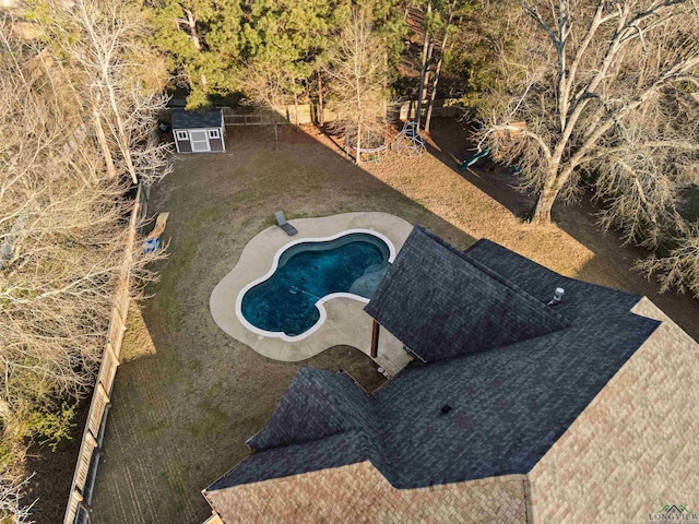 view of pool with a patio and a shed