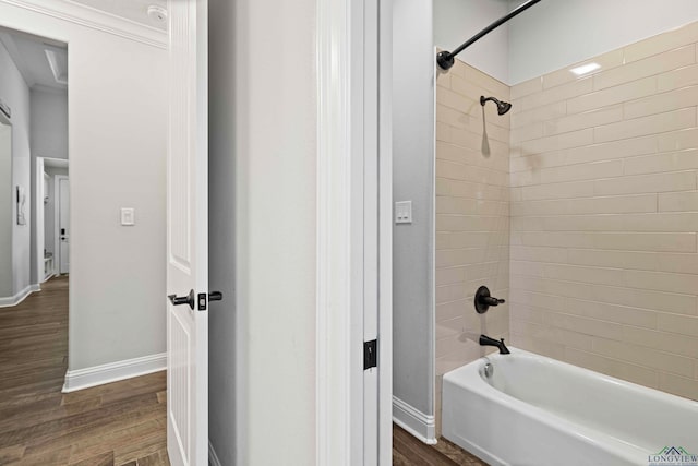 bathroom with ornamental molding, tiled shower / bath combo, and wood-type flooring