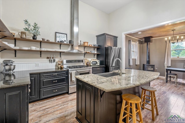 280 S Stonewall St, Tatum, TX 75691 - kitchen featuring appliances with stainless steel finishes, open shelves, a sink, a kitchen bar, and light wood-type flooring