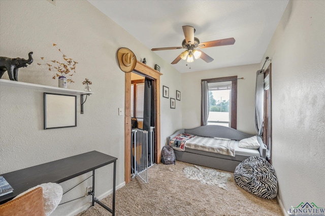 280 S Stonewall St, Tatum, TX 75691 - carpeted bedroom with a textured wall, baseboards, and a ceiling fan