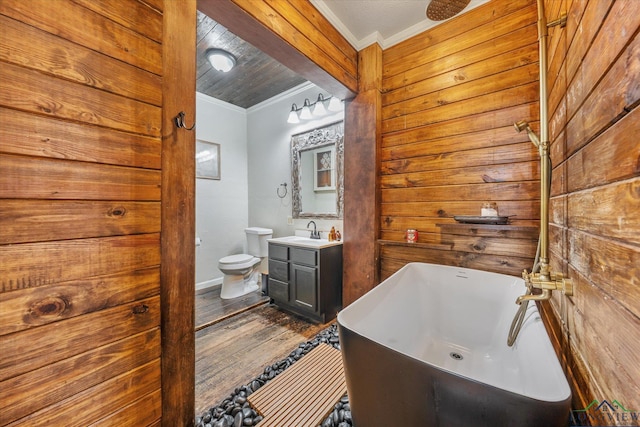 280 S Stonewall St, Tatum, TX 75691 - bathroom with crown molding, a soaking tub, vanity, wood finished floors, and toilet