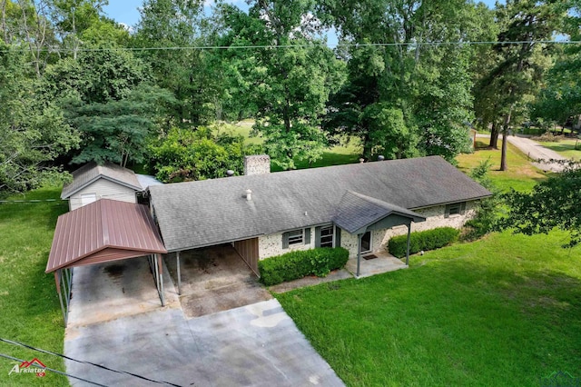 711 Comer St, Carthage, TX 75633 - ranch-style home featuring an attached carport, a chimney, a front lawn, concrete driveway, and a shingled roof
