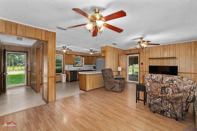 711 Comer St, Carthage, TX 75633 - living room with wood walls, a textured ceiling, light wood finished floors, ceiling fan, and ornamental molding